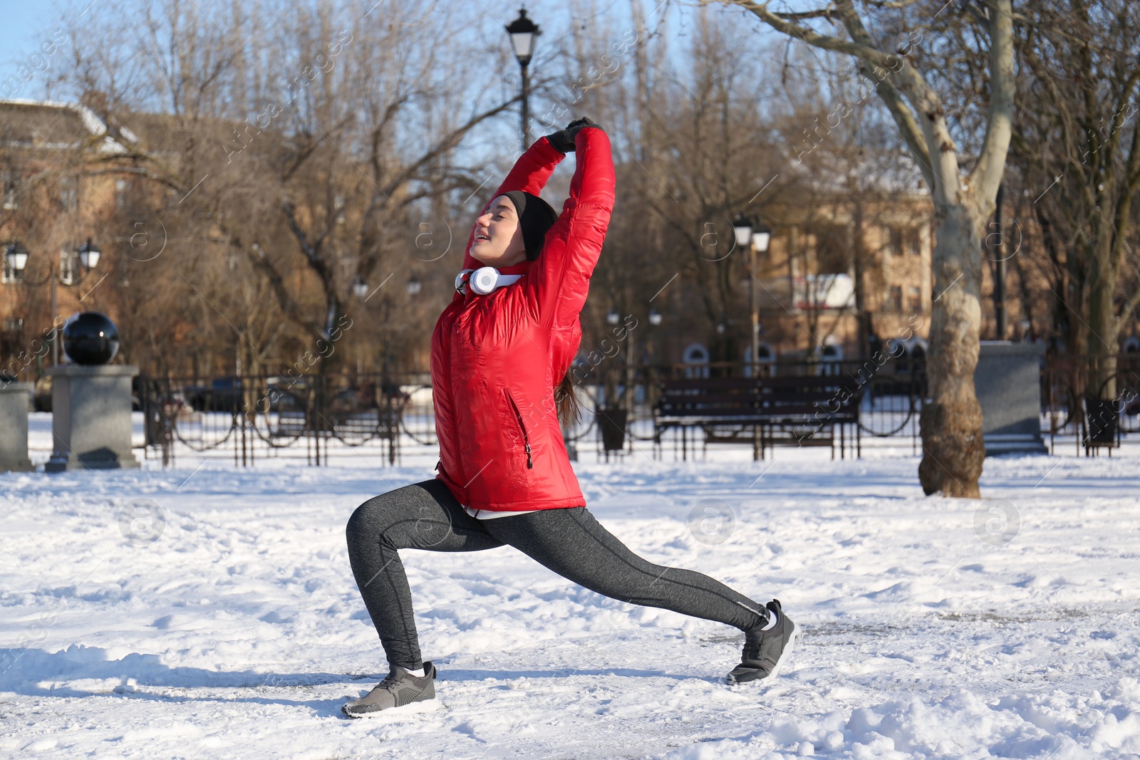 Photo of Happy woman doing sports exercises in snowy park on winter day