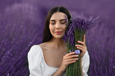 Beautiful young woman with bouquet in lavender field