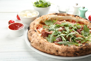 Photo of Tasty pizza with meat and arugula on white wooden table, closeup