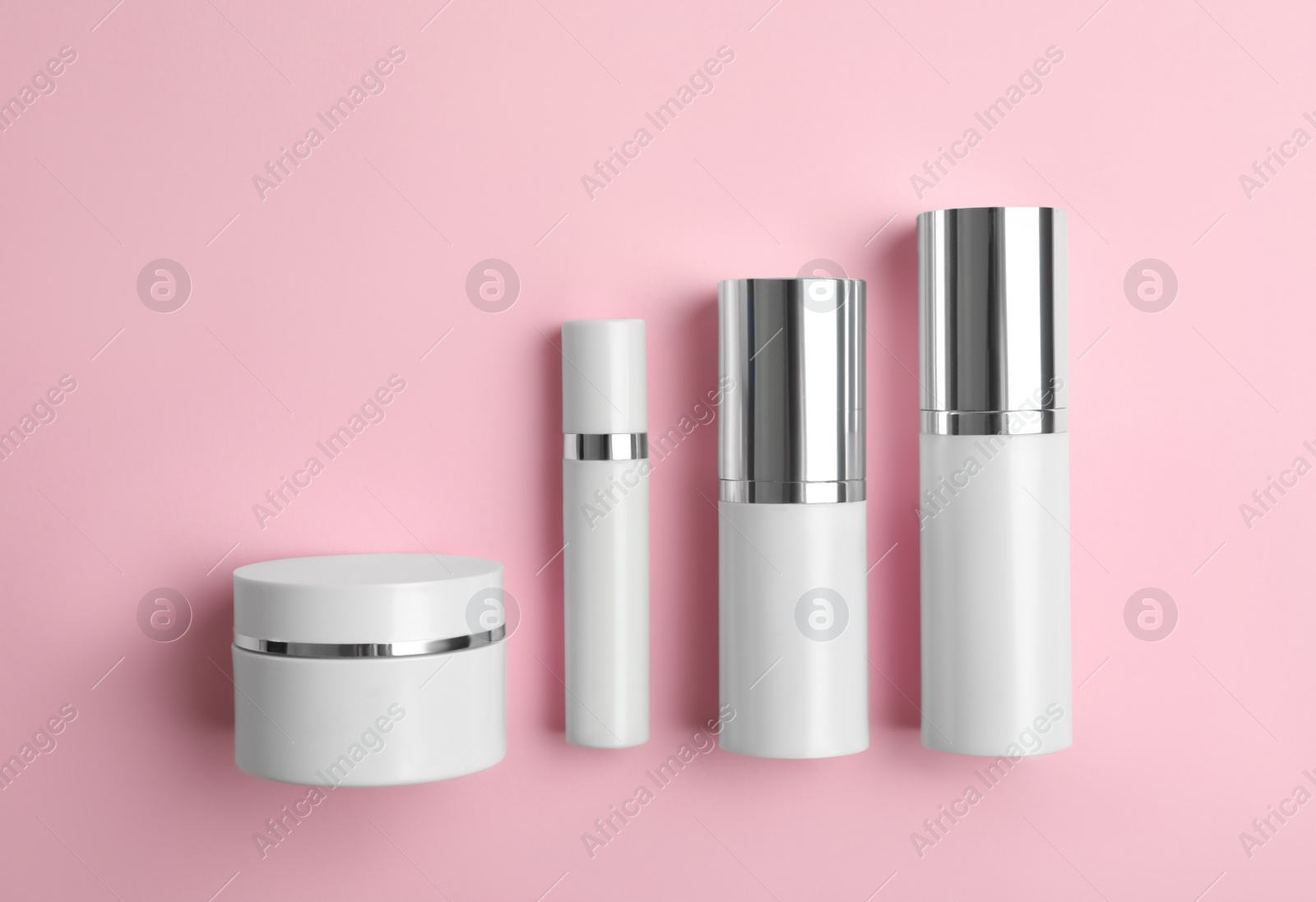 Photo of Set of luxury cosmetic products on pink background, flat lay