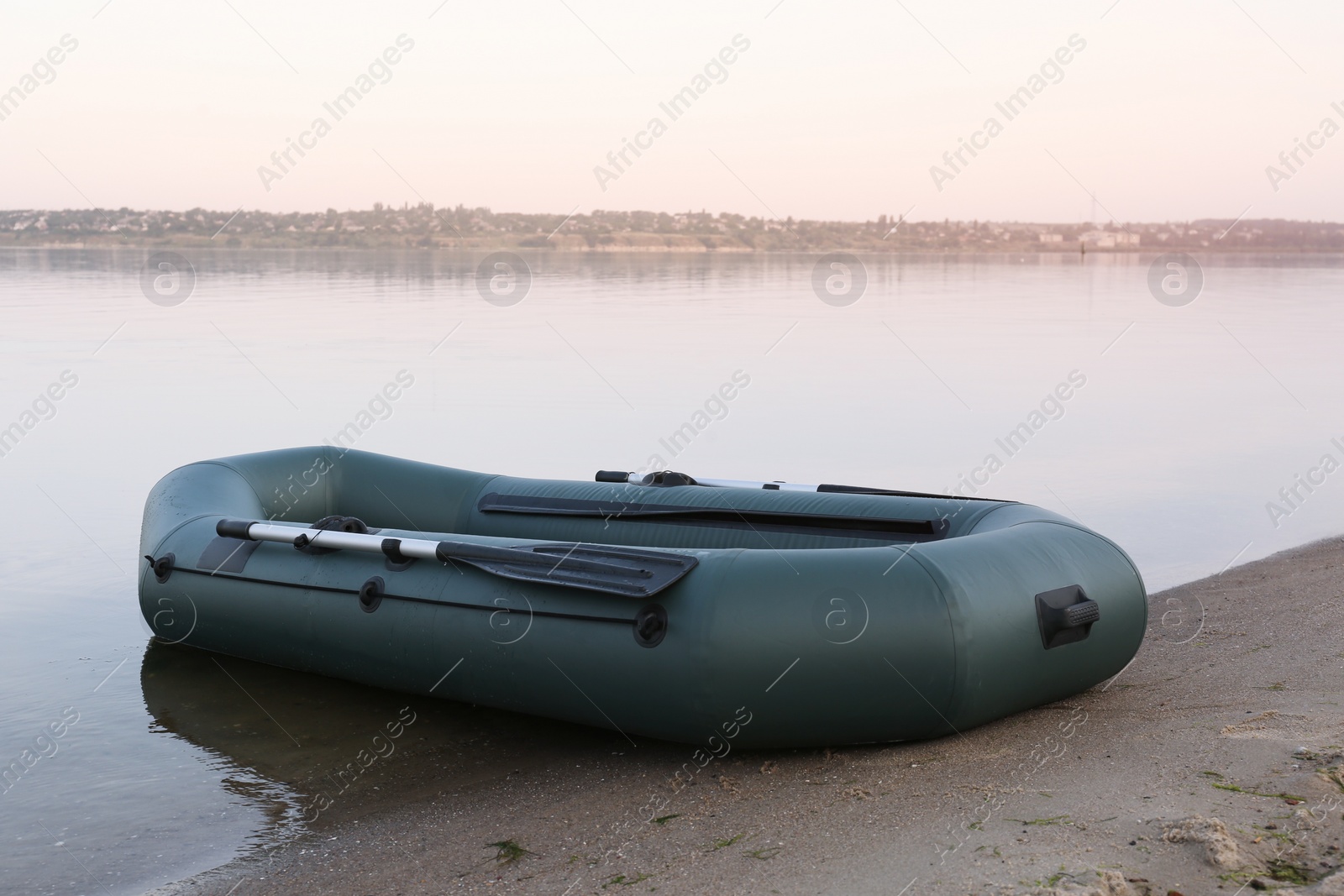 Photo of Inflatable rubber fishing boat on sandy beach near river