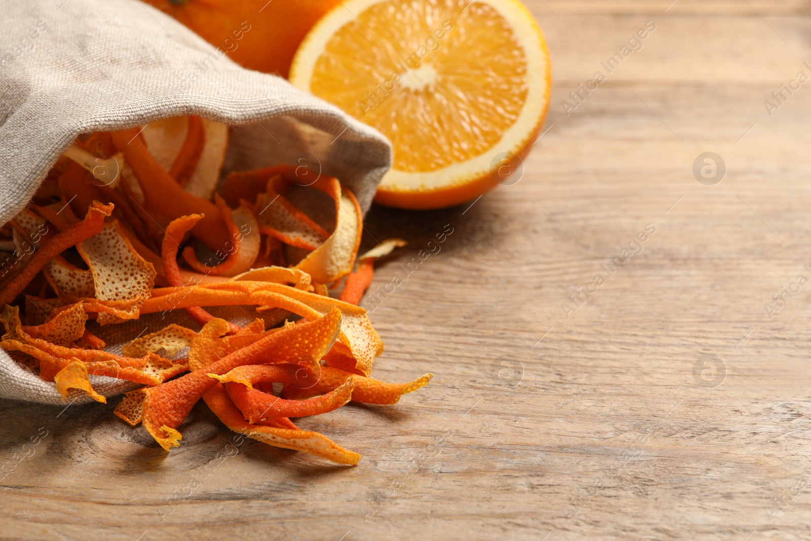 Photo of Dry orange peels and fresh fruit on wooden table, space for text