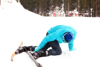 Clumsy skier on slope at resort. Winter vacation