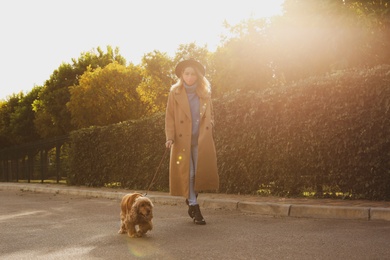 Photo of Woman in protective mask with English Cocker Spaniel outdoors. Walking dog during COVID-19 pandemic