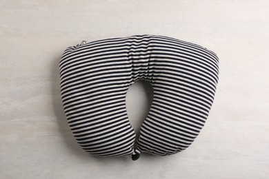Striped travel pillow on light background, top view