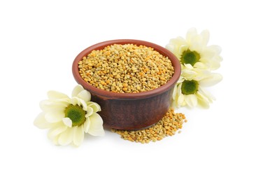 Photo of Fresh bee pollen granules in bowl and flowers isolated on white