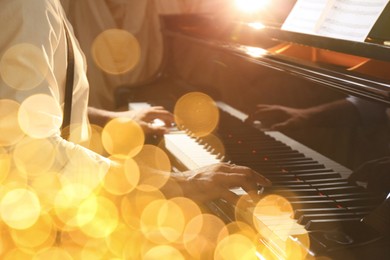 Image of Christmas and New Year music. Man playing piano, closeup. Bokeh effect