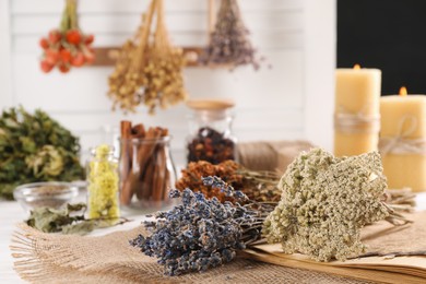 Photo of Different dry herbs and flowers on white table