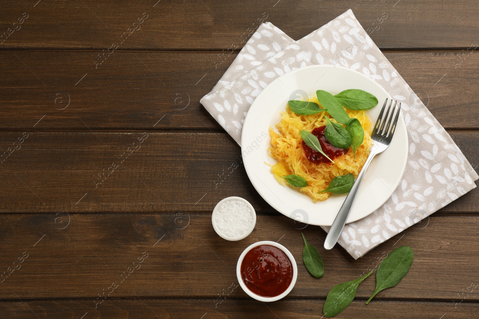 Photo of Tasty spaghetti squash with tomato sauce and basil served on wooden table, flat lay. Space for text