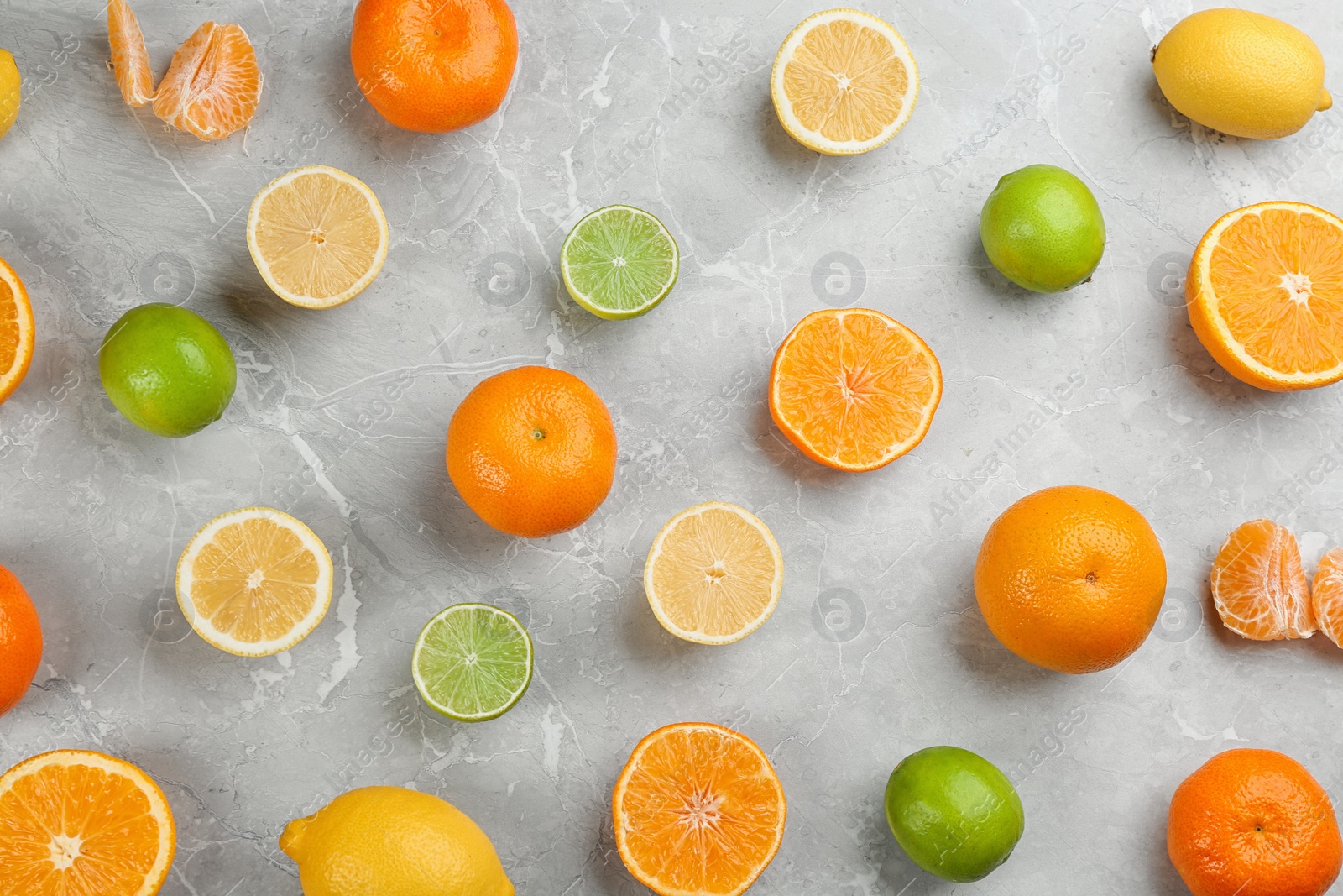 Photo of Flat lay composition with tangerines and different citrus fruits on grey marble background