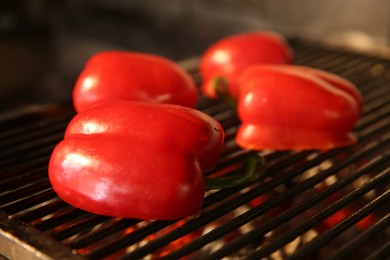 Cooking delicious fresh bell peppers on grilling grate in oven, closeup