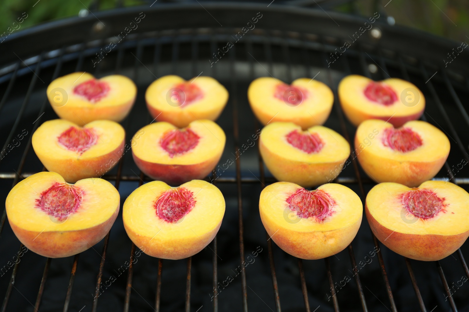 Photo of Modern grill with tasty cut peaches, closeup