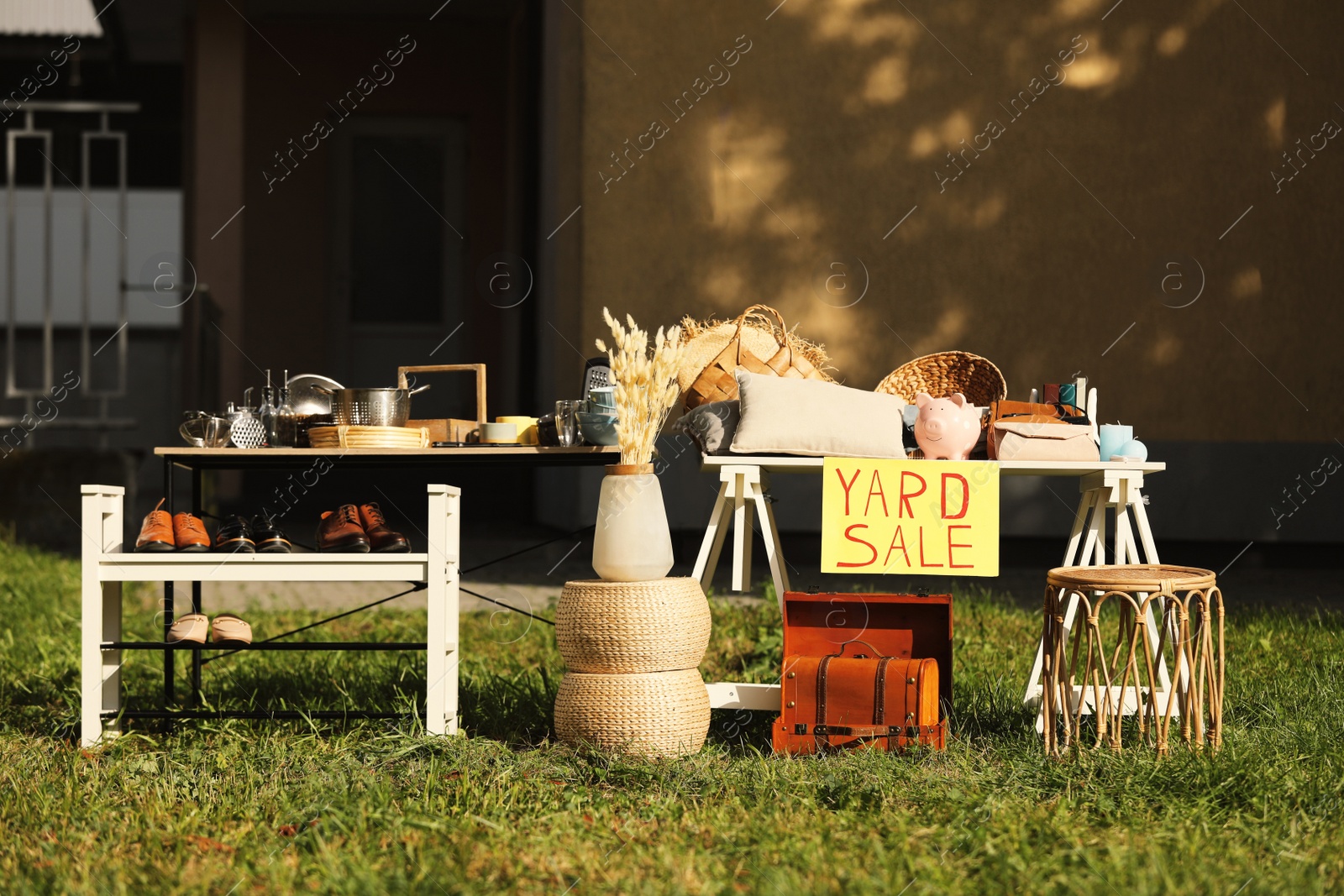Photo of Table with different stuff and sign Yard sale outdoors