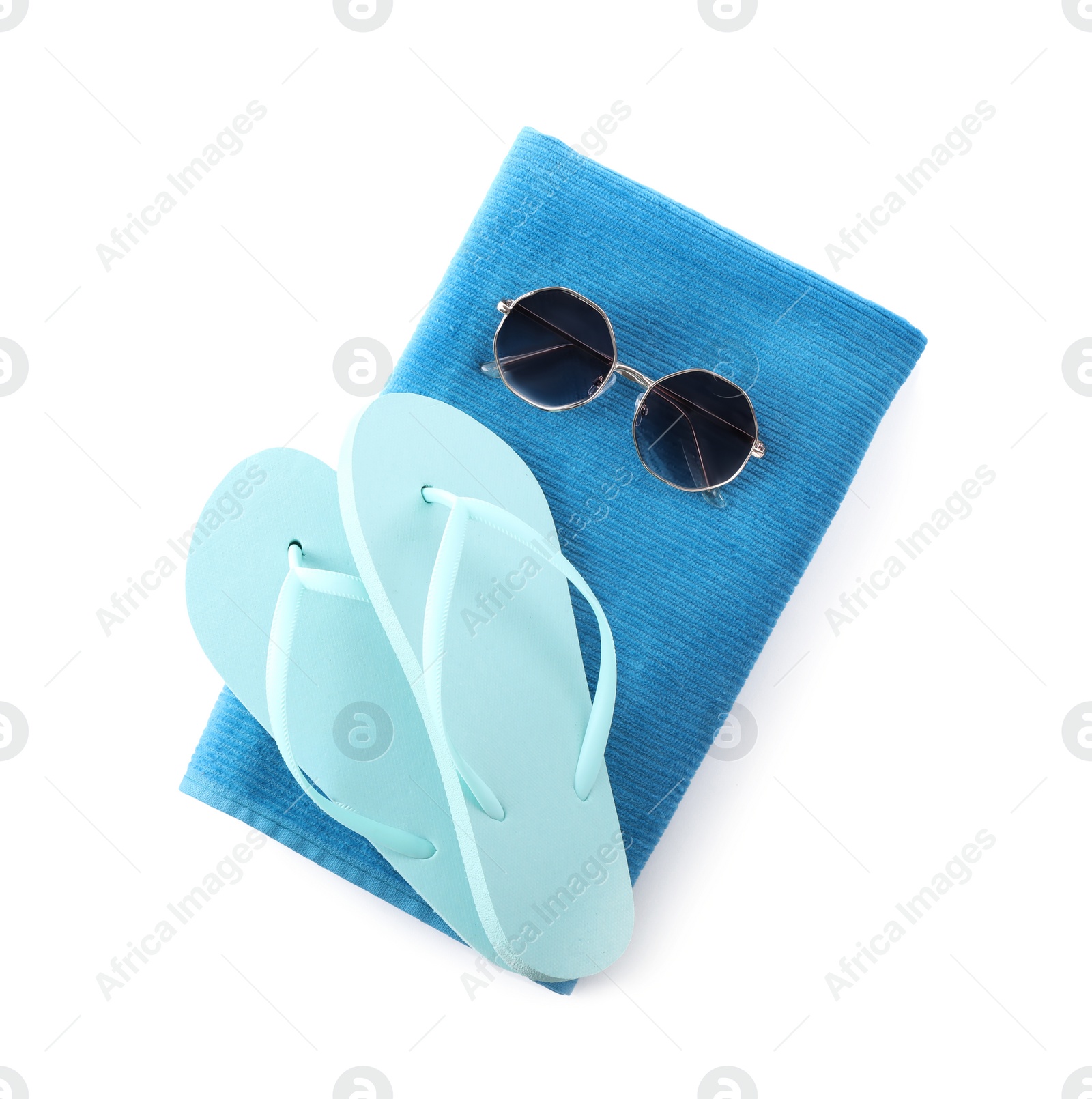 Photo of Blue towel, flip flops and sunglasses on white background, top view. Beach objects