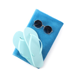 Photo of Blue towel, flip flops and sunglasses on white background, top view. Beach objects