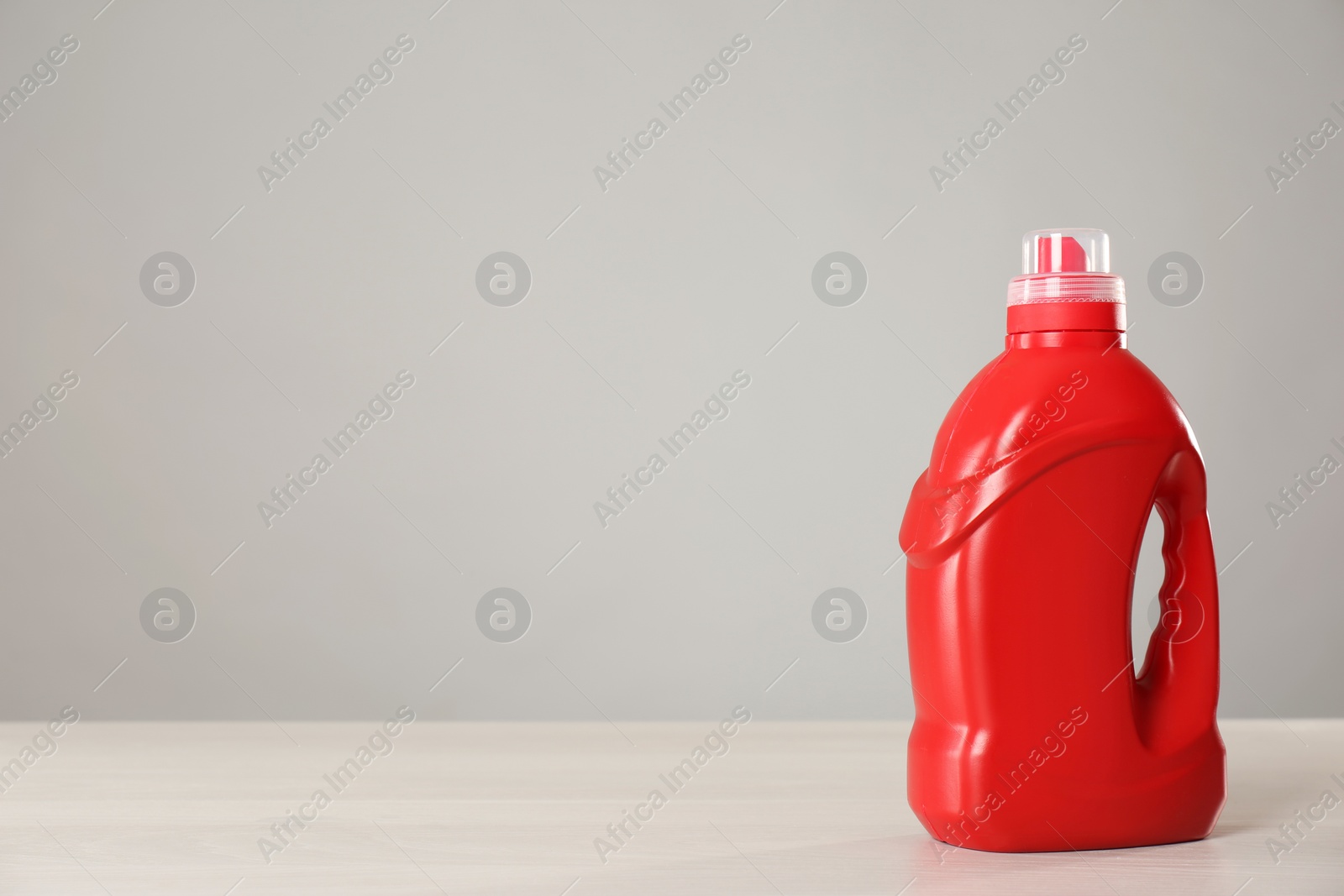 Photo of Bottle of cleaning product on light table. Space for text