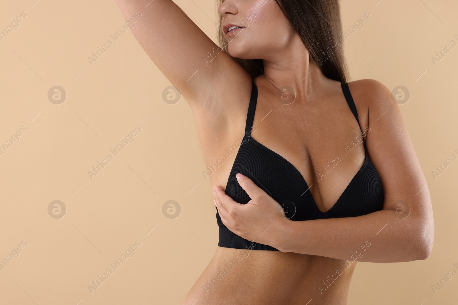 Photo of Woman with beautiful breast on beige background, closeup. Space for text