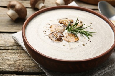 Photo of Fresh homemade mushroom soup served on wooden table, closeup