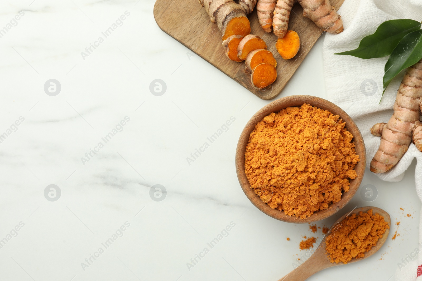 Photo of Aromatic turmeric powder, raw roots and leaves on white marble table, flat lay. Space for text