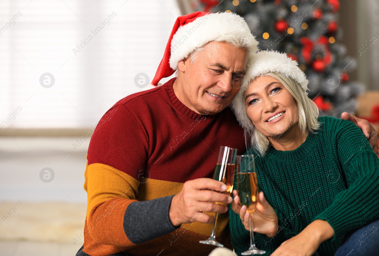 Photo of Happy mature couple with glasses of champagne at home. Christmas celebration