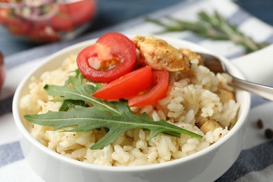 Delicious chicken risotto served in bowl, closeup