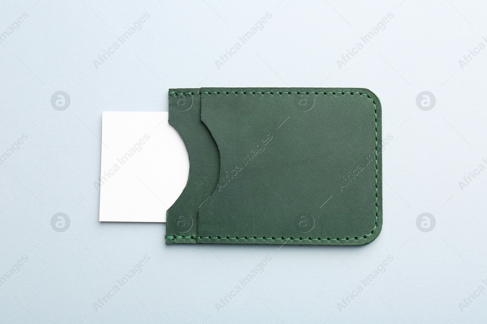 Photo of Leather business card holder with blank card on light grey background, top view