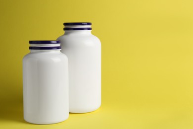 Photo of Medicine bottles on yellow background, space for text