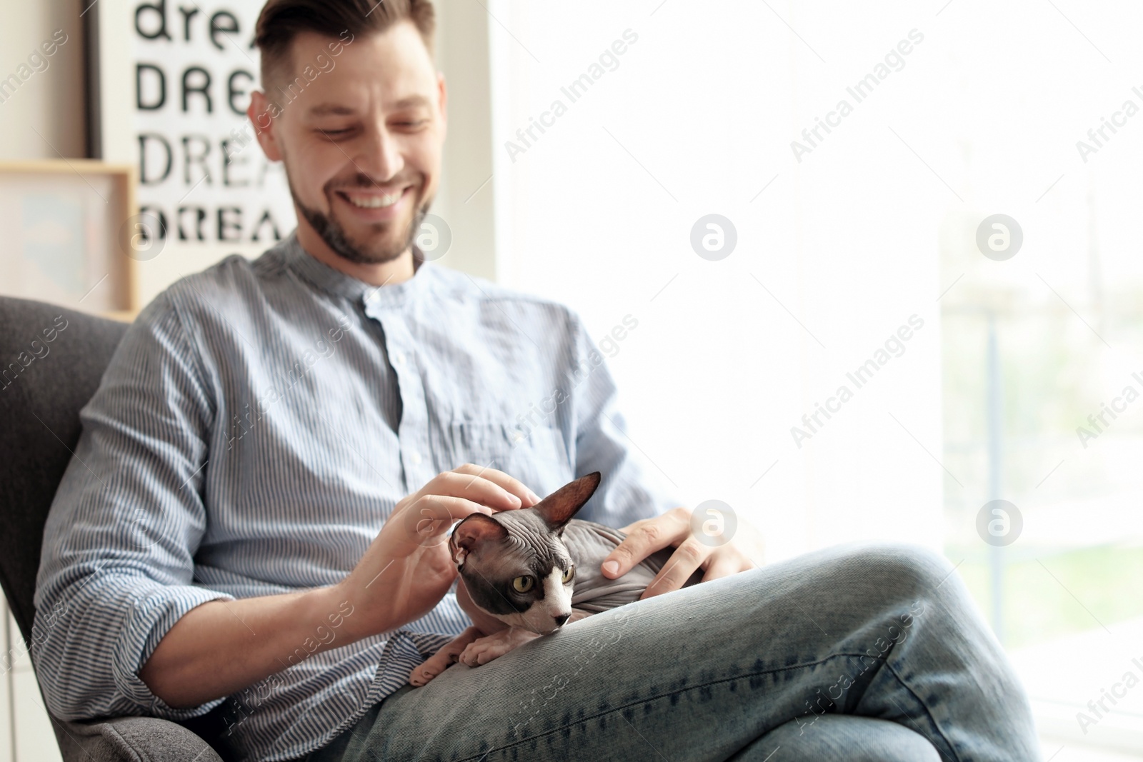 Photo of Young man with cute cat at home