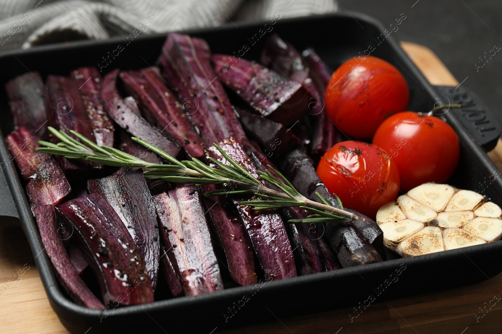 Photo of Cut raw carrot with vegetables and rosemary in baking dish, closeup