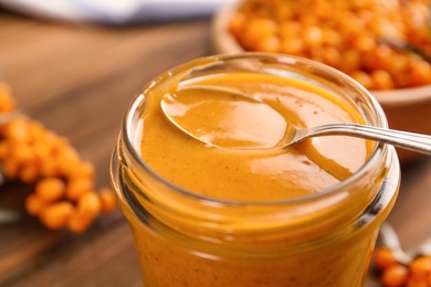 Photo of Delicious sea buckthorn jam in jar, closeup