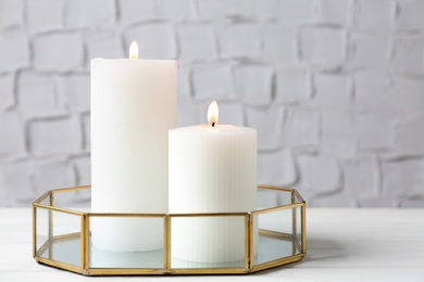 Photo of Tray with burning candles on white table indoors