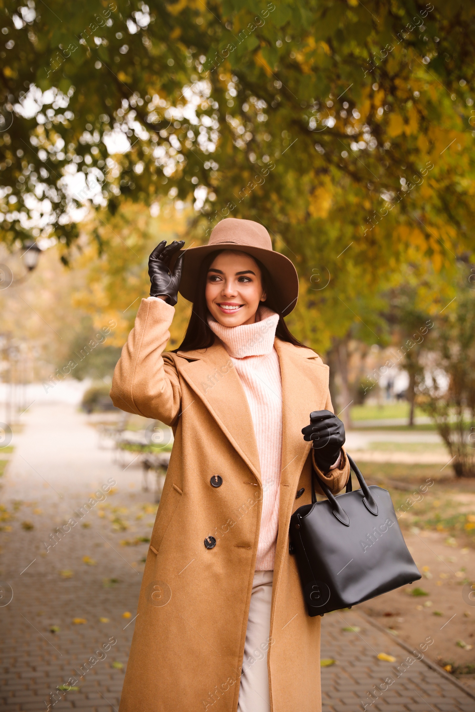 Photo of Young woman wearing stylish clothes in autumn park