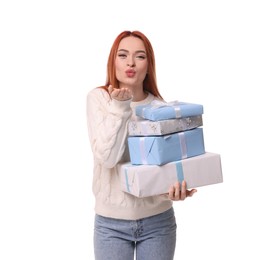 Photo of Young woman in sweater with Christmas gifts blowing kiss on white background