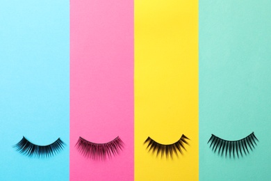 Photo of False eyelashes on color background, flat lay. Space for text