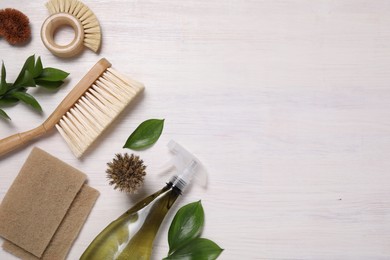 Flat lay composition with different cleaning supplies on light wooden background, space for text