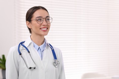 Photo of Medical consultant with glasses and stethoscope in clinic, space for text