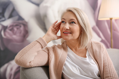 Beautiful mature woman on sofa at home