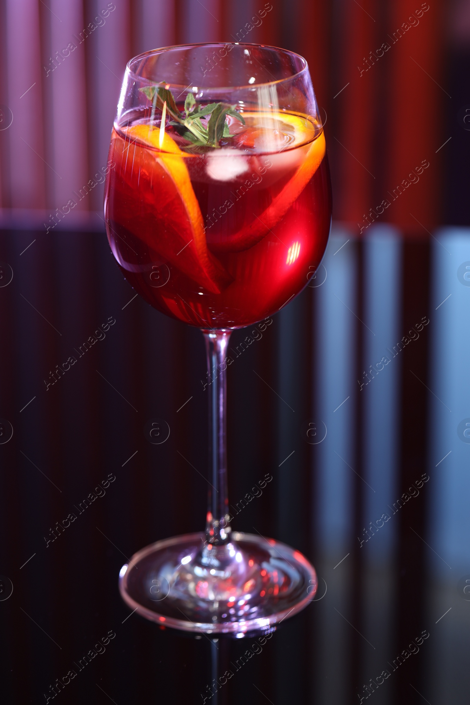 Photo of Glass of delicious refreshing sangria on counter in bar