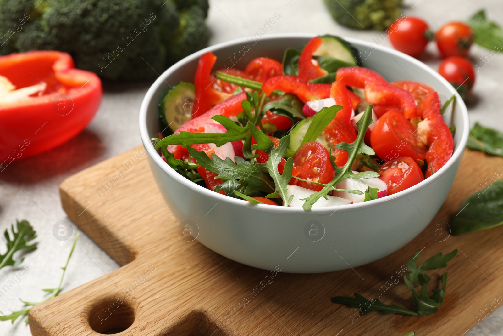 Photo of Tasty fresh vegetarian salad on light grey table, closeup