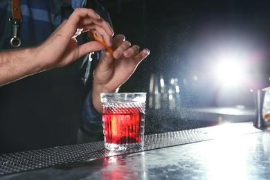 Barman making Red Russian cocktail at counter in pub, closeup. Space for text