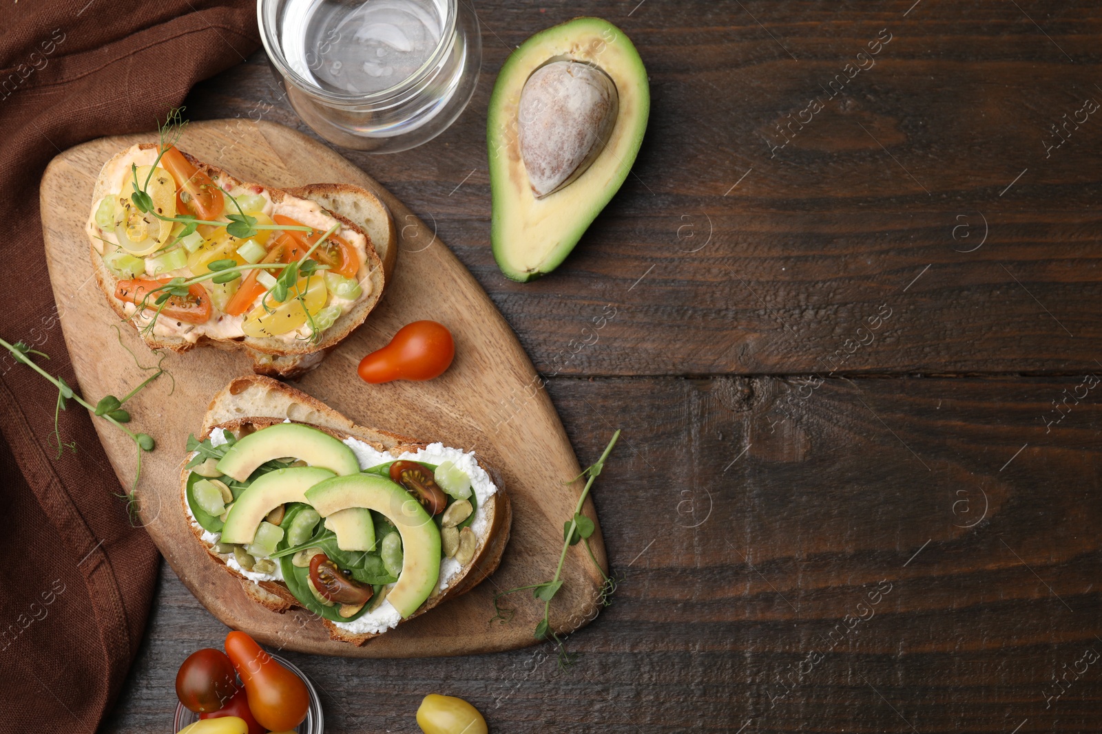 Photo of Tasty vegan sandwiches with vegetables on wooden table, flat lay. Space for text