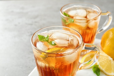 Photo of Cups of refreshing iced tea on light table