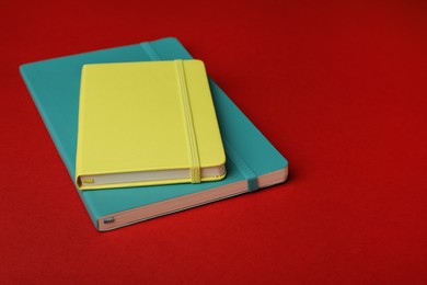 Photo of New stylish bright planners on red background
