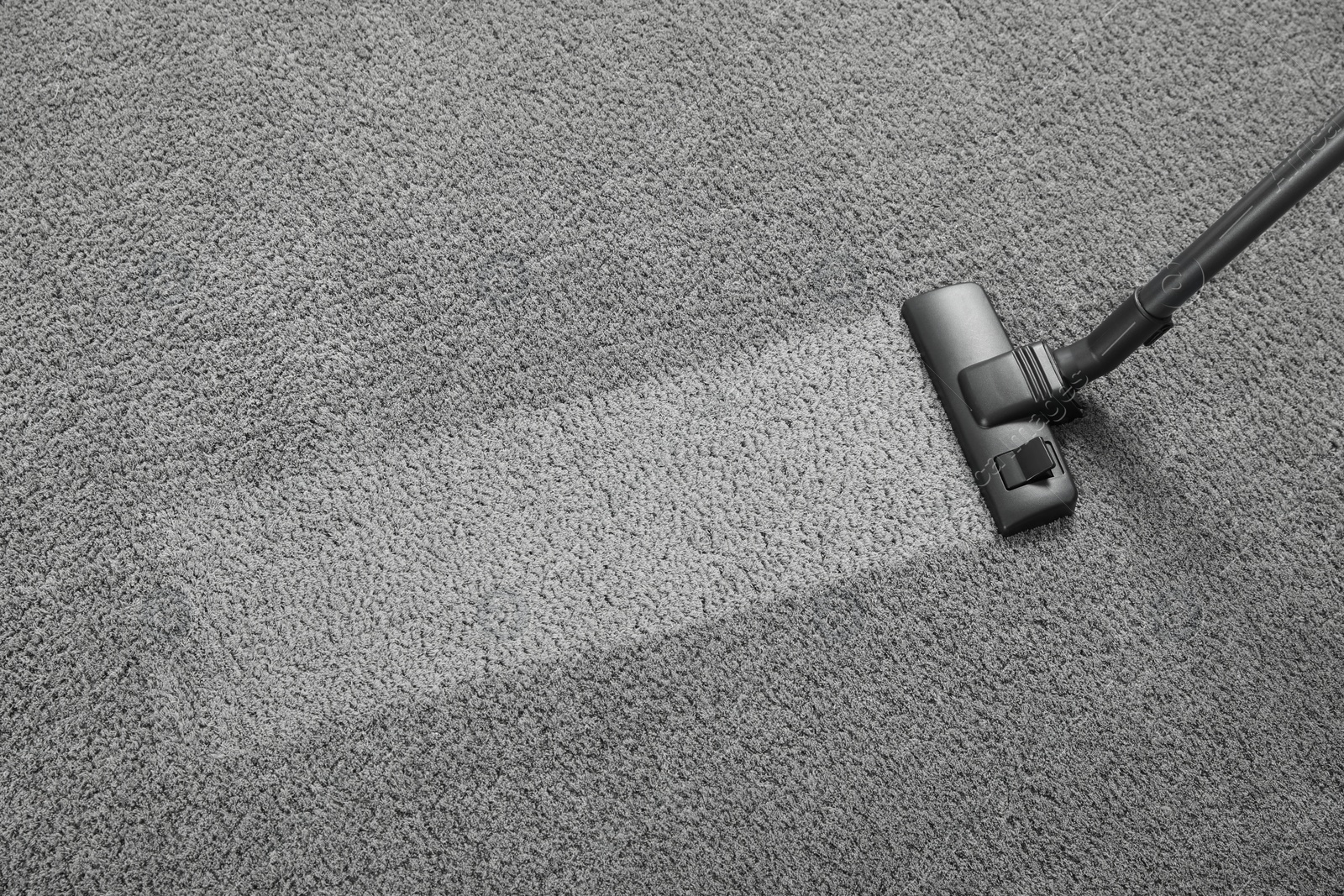 Photo of Vacuuming grey carpet, above view. Clean area after using device. Space for text