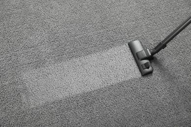 Photo of Vacuuming grey carpet, above view. Clean area after using device. Space for text