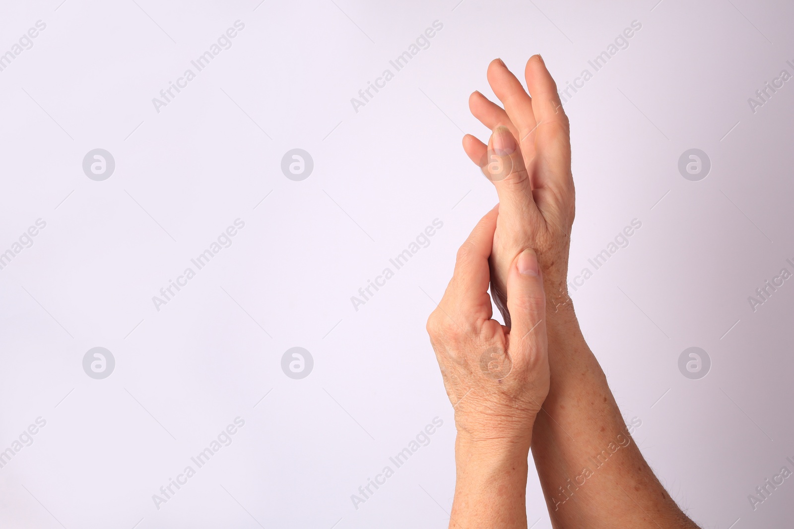 Photo of Closeup view of older woman's hands on white background. Space for text