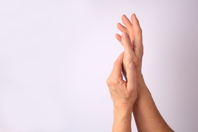 Closeup view of older woman's hands on white background. Space for text