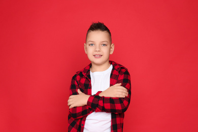 Portrait of cute little boy on red background