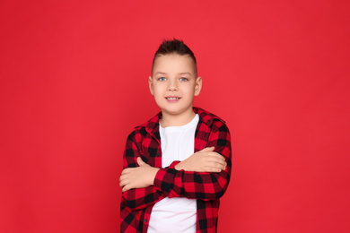 Photo of Portrait of cute little boy on red background