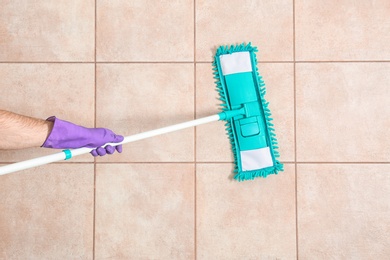 Man cleaning floor with mop, top view